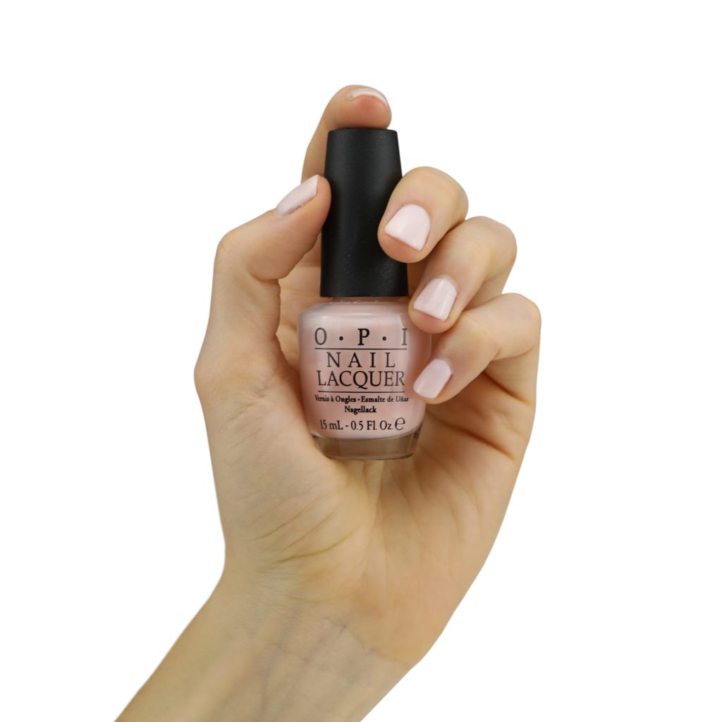 Hand model product photo on white background of hand holding pink nail polish