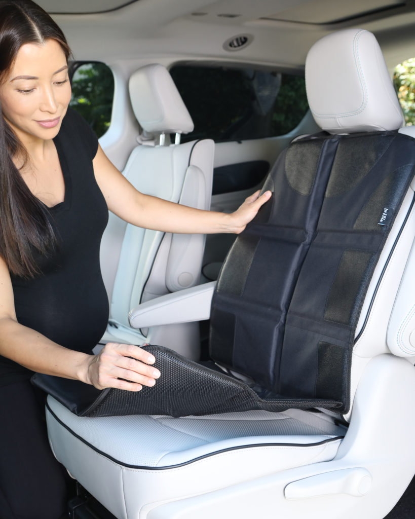 Product photo of woman wearing black demonstrating baby car seat mat