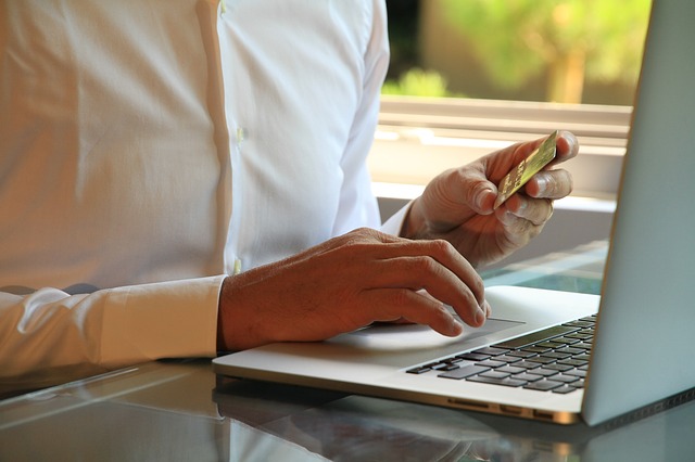 lifestyle photo of man paying with credit card on laptop amazon sellers, product photography