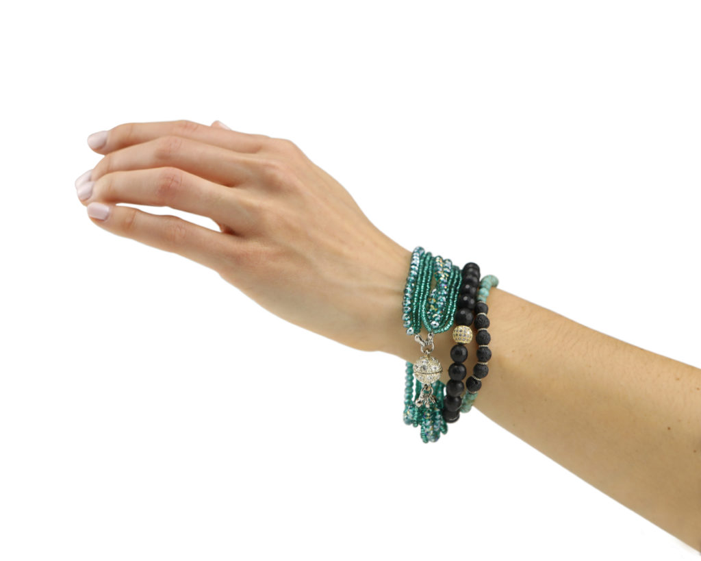 Hand model product photo on white background of hand wearing turquoise and black beaded bracelets