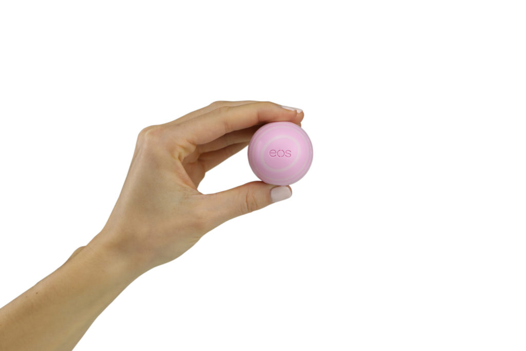 Hand model product photo on white background of hand holding a pink eos ball