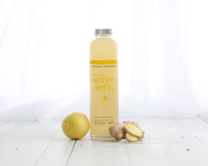 Mini lifestyle photo with Lemon Ginger Beverage tabletop with white wood and white curtains product photograph