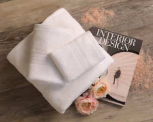 mini lifestyle photo of white towel and interior design magazine wooden tabletop product photograph