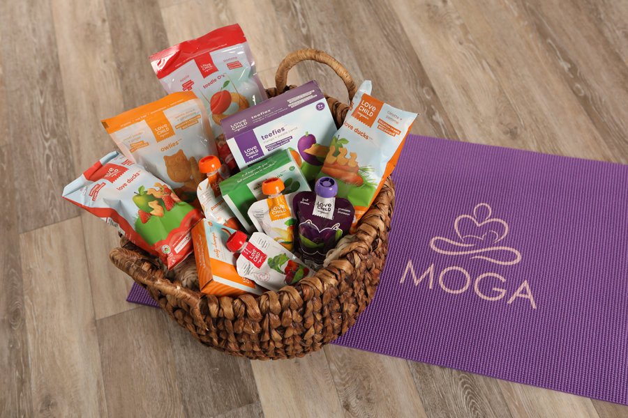 Mini lifestyle photo of basket of baby snacks and drinks on a purple yoga mat on a wood floor