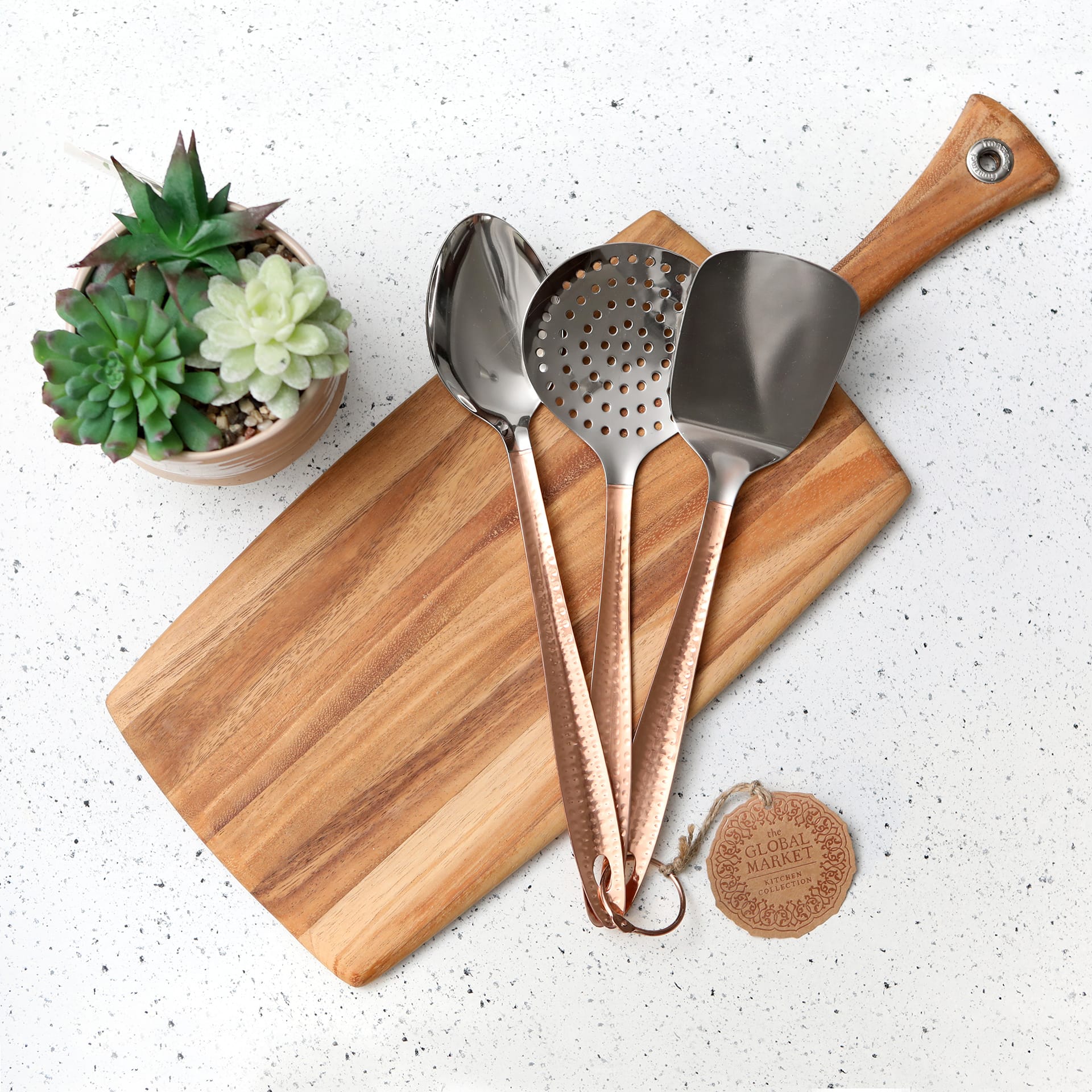 top down photo of kitchen counter with cutting board and kitchen utensils and plant