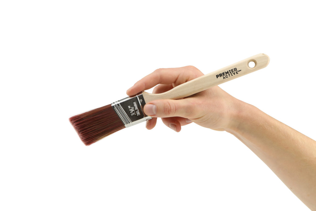 Hand model product photo on white background of hand holding a premier active paint brush