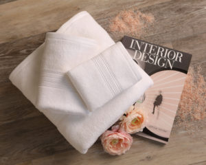 mini lifestyle photo of white towel and interior design magazine wooden tabletop product photograph